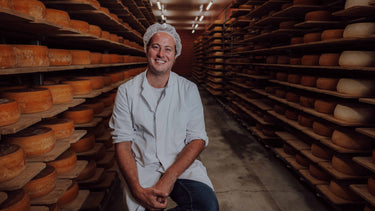 Thilo sitzt im Käsekeller und schaut den Betrachter an