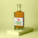 Flasche goldgelber Apfellikör schräg von der Seite.