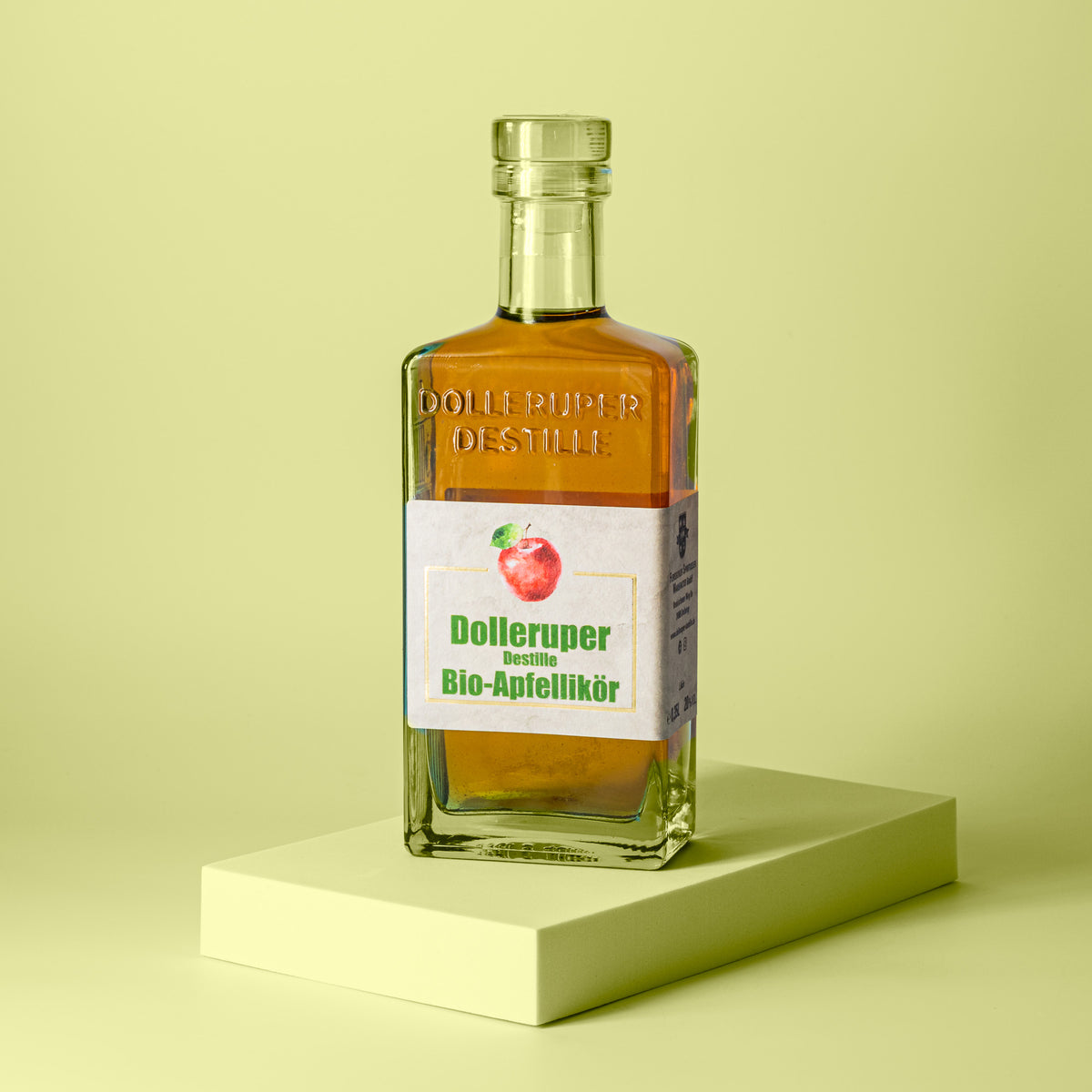 Flasche goldgelber Apfellikör schräg von der Seite.