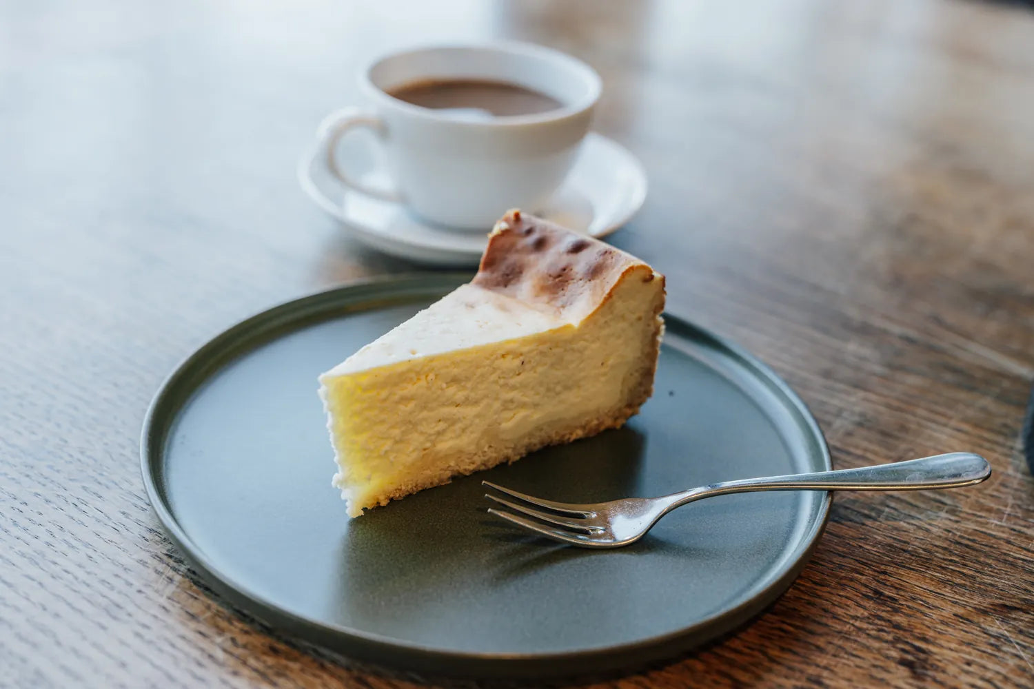 Ein Stück Käsekuchen mit einem Cappuchino