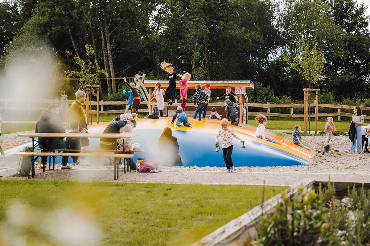 Viele Kinder spielen auf einem Hüpfkissen