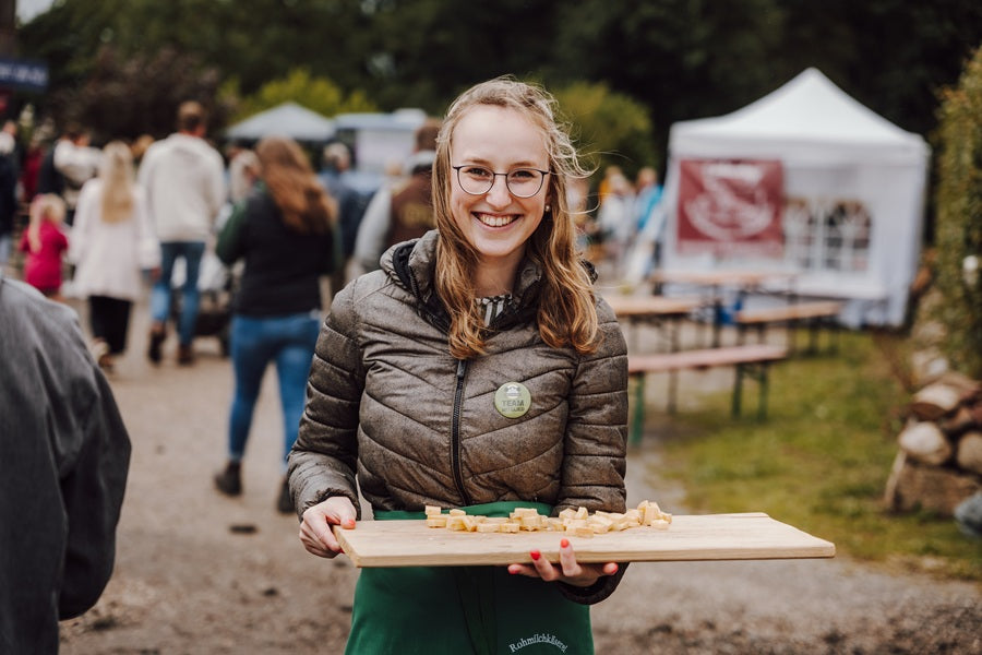 Eine Frau hat Käse zum Verkosten auf einem Brett.