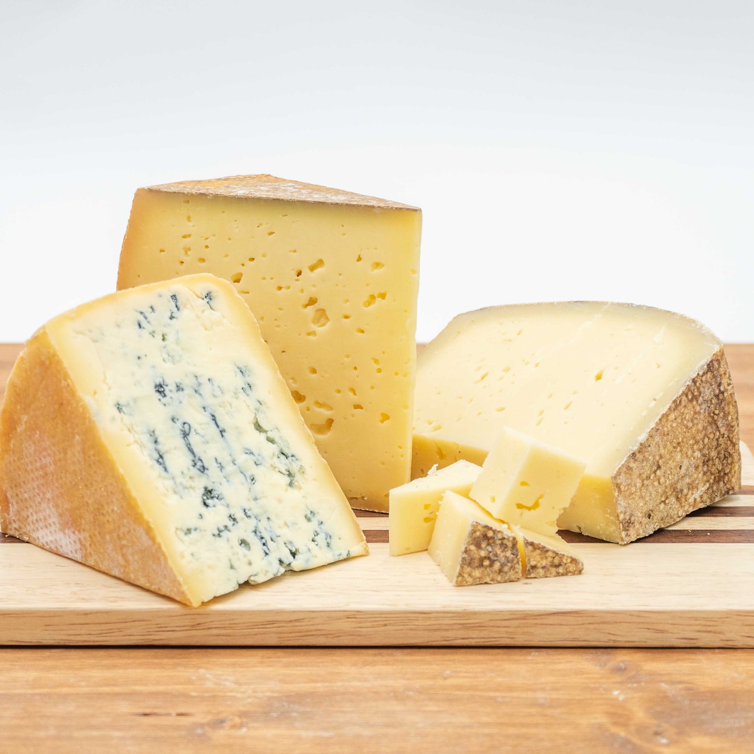 Die Käse Friesisch Blue, Deichkäse Alt und Michel liegen auf einem Brett