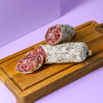 Lavendel Salami halbiert in zwei Stücke auf Holzbrett.