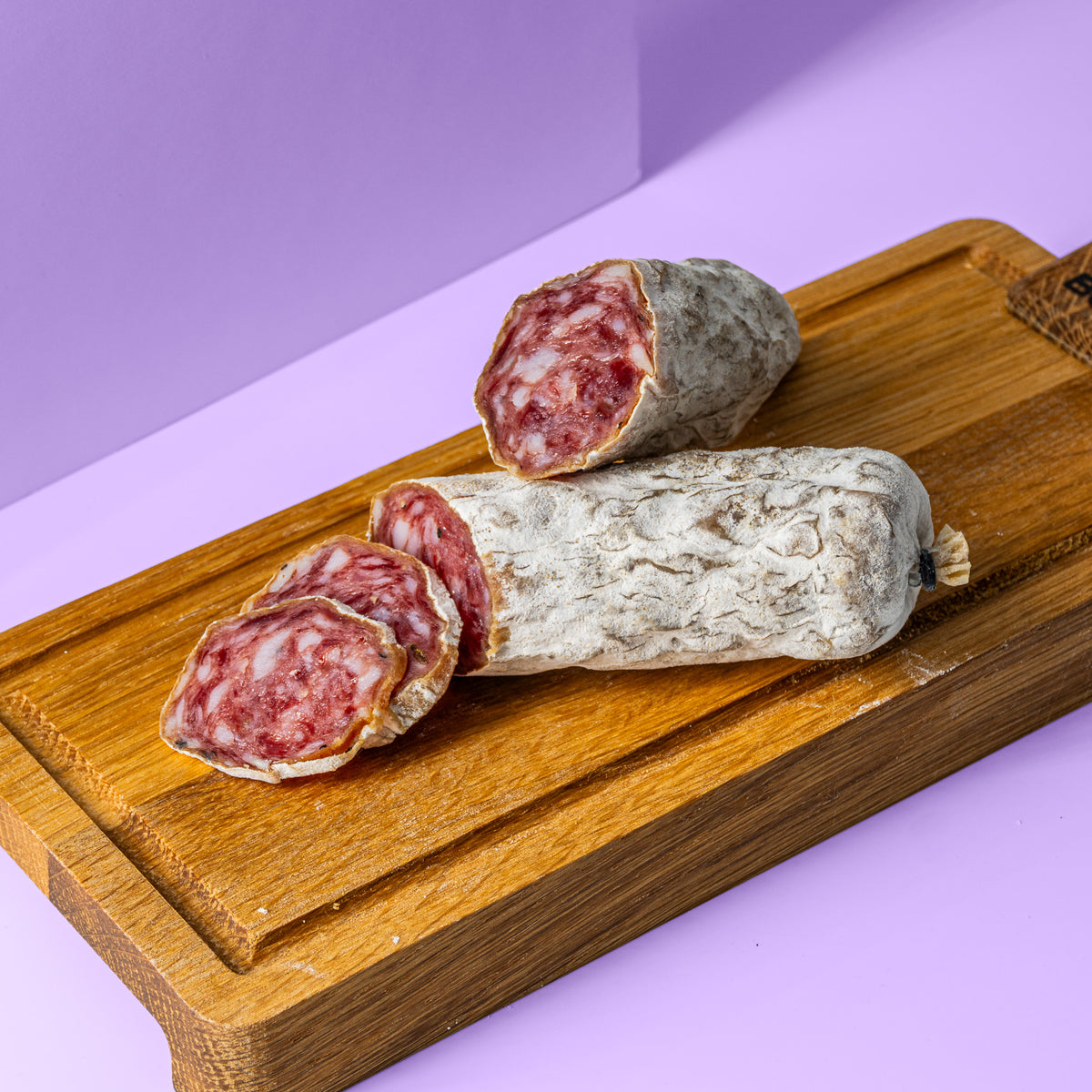 Lavendel Salami halbiert in zwei Stücke auf Holzbrett.