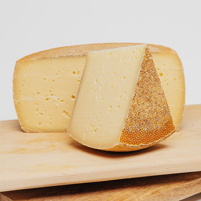 Ein großer Laib Käse, 4,5 Kg schwer. Die Farbe ist hellgelb und der Käse ist halb aus Ziegen und halb aus Kuhmilch.