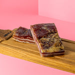 Zwei Stücke Mini-Pancetta auf Holzbrett