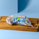 Salami Milano mit blau weißer Banderole auf Holzbrett.