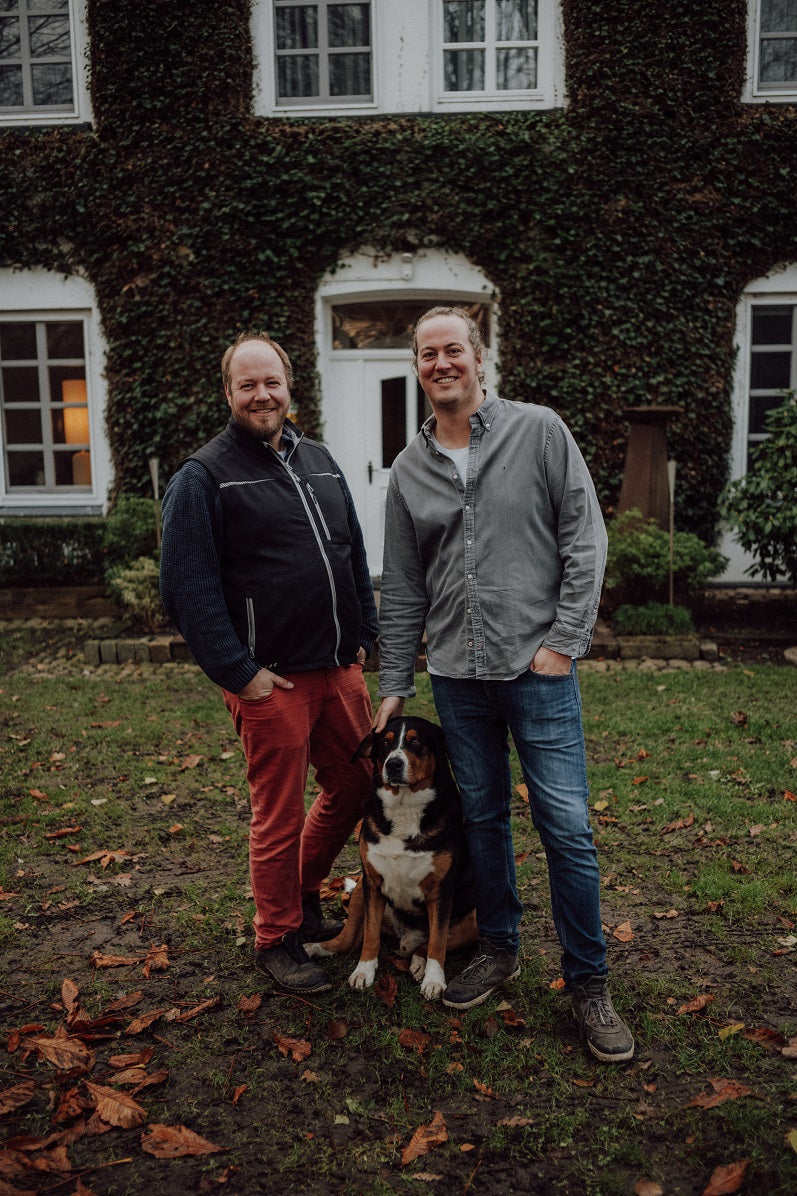 Thilo und Jasper Metzger-petersen mit einem Schweizer Sennenhund vor einem Wohnhaus.