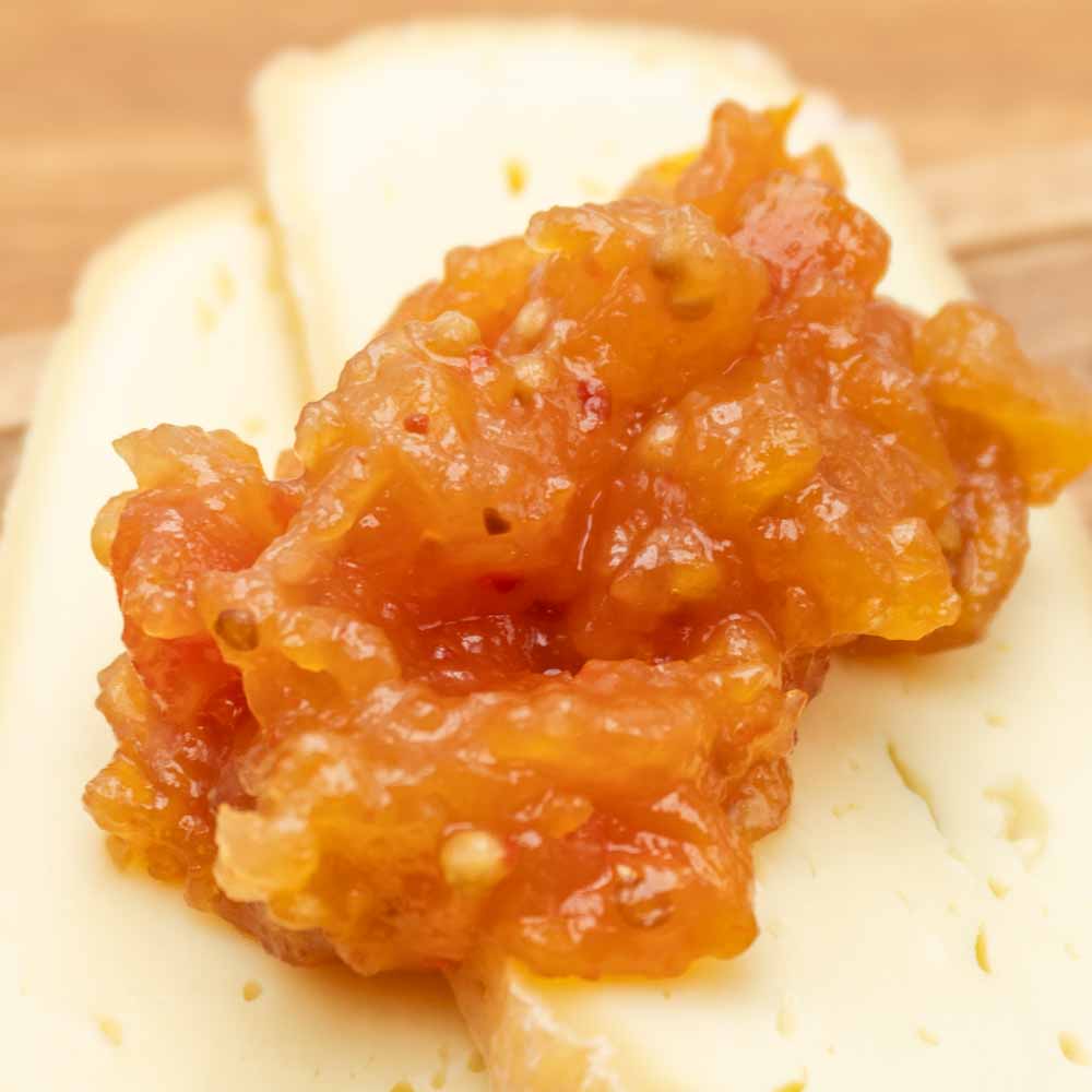 Tomaten Relish auf einem Stück Käse angerichtet.