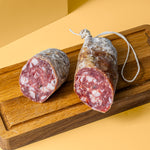 Trüffel Salami halbiert auf Holzbrett.